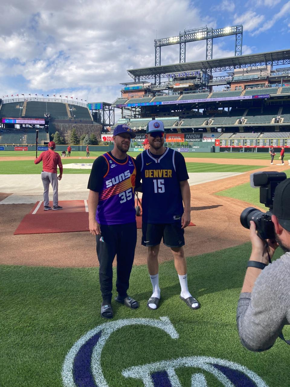 Arizona Diamondbacks pitcher Merrill Kelly and Colorado Rockies pitcher Kyle Freeland pose for a picture Saturday before the teams played.  They wore jerseys supporting the Phoenix Suns and Denver Nuggets, respectively, who were to tip off in their NBA Western Conference Semifinals series in Denver Saturday night.