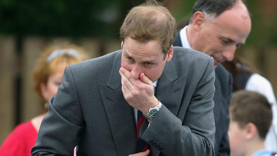 Prince William stifles a sneeze during a visit to a Primary School