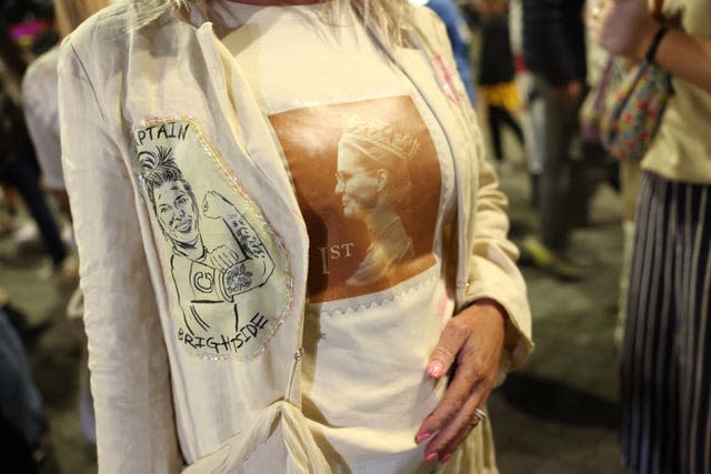 An England fan wears a Millie Bright 'Captain Brightside' jacket and a T-shirt with Sarina Wiegman styled as the Queen