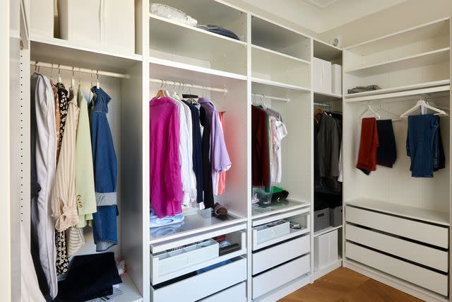 <p>Getty</p> Clothes hang in a closet