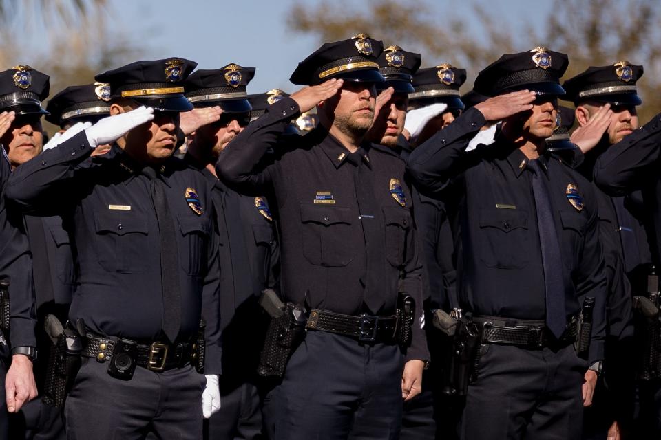 The Las Cruces Police Department salutes the procession's arrival for fallen Officer Jonah Hernandez at Abundant Church on Wednesday in El Paso.