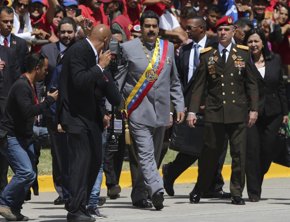 FILE - In this Feb. 1, 2017, file photo, Gen. Ivan Hernández, head of both the presidential guard and military counterintelligence, right, keeps an eye on Venezuela's President Nicolas Maduro as he arrives for a military parade at Fort Tiuna in Caracas, Venezuela. The Associated Press has learned that at least twice since 2016, the U.S. government missed chances to cultivate relations with regime insiders, including Hernández, who National Security Adviser John Bolton said backed out of a plan to topple Maduro. (AP Photo/Fernando Llano, File)