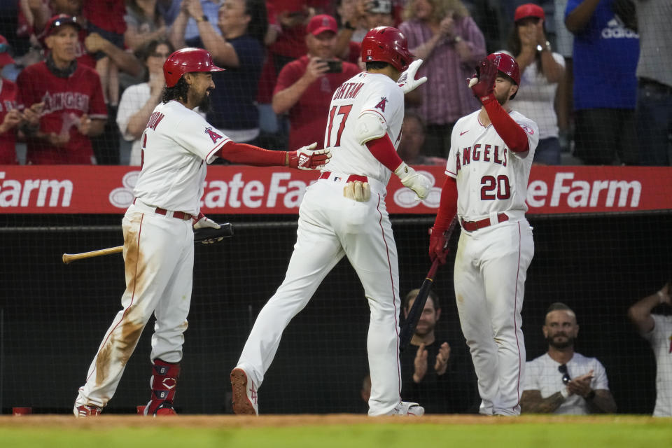 Los Angeles Angels designated hitter Shohei Ohtani (17) celebrates with Anthony Rendon, left, and Jared Walsh (20) after hitting a home run during the fourth inning of a baseball game against the Baltimore Orioles Friday, July 2, 2021, in Anaheim. David Fletcher also scored. (AP Photo/Ashley Landis)