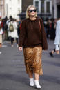 <p>A London Fashion Week guest wears a brown pullover, leopard-print skirt, and white boots on Sept. 15, 2018, in London. (Photo: Edward Berthelot/Getty Images) </p>