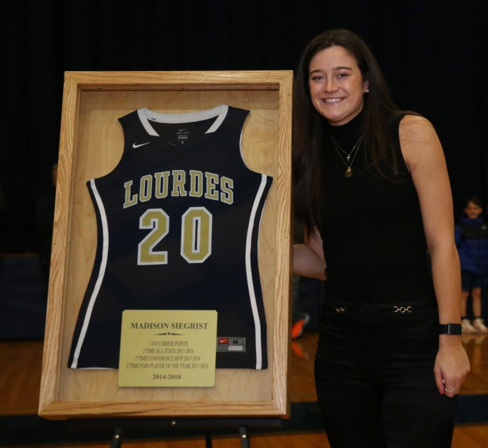 Maddy Siegrist beside her retired jersey during a ceremony at Our Lady of Lourdes High School in the Town of Poughkeepsie on January 4, 2024.