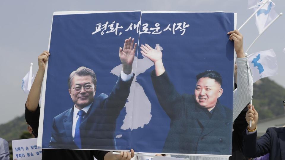 Nordkoreas Machthaber Kim Jong Un (r) und der südkoreanische Präsident Moon Jae sind in Seoul auf einem Plakat von Aktivisten zu sehen. Foto: Lee Jin-Man/AP