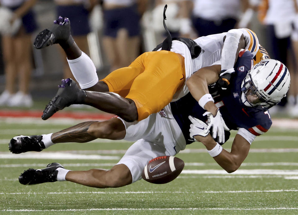 Arizona wide receiver Tetairoa McMillan (4) loses the ball after being hit by UTEP safety Kobe Hylton (2) during an NCAA college football game on Saturday, Sept. 16, 2023, in Tucson, Ariz. (Kelly Presnell/Arizona Daily Star via AP)