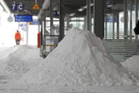 A Deutsche Bahn employee clears snow on a platform at the main station in Magdeburg, Germany, Sunday, Feb. 7, 2021. (Peter Gercke/dpa via AP)