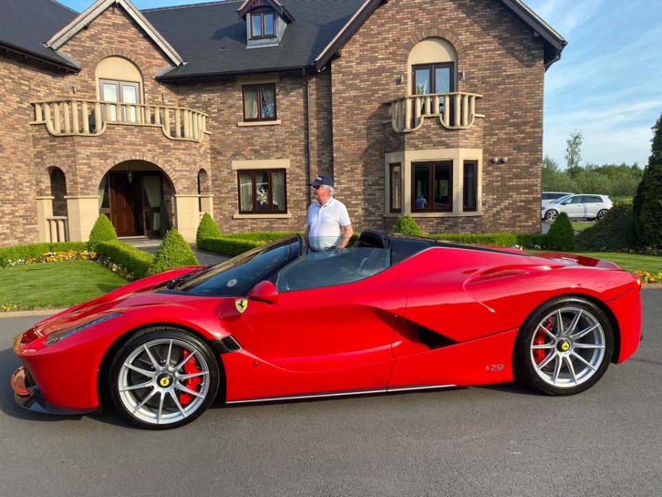 a red car in front of a large house