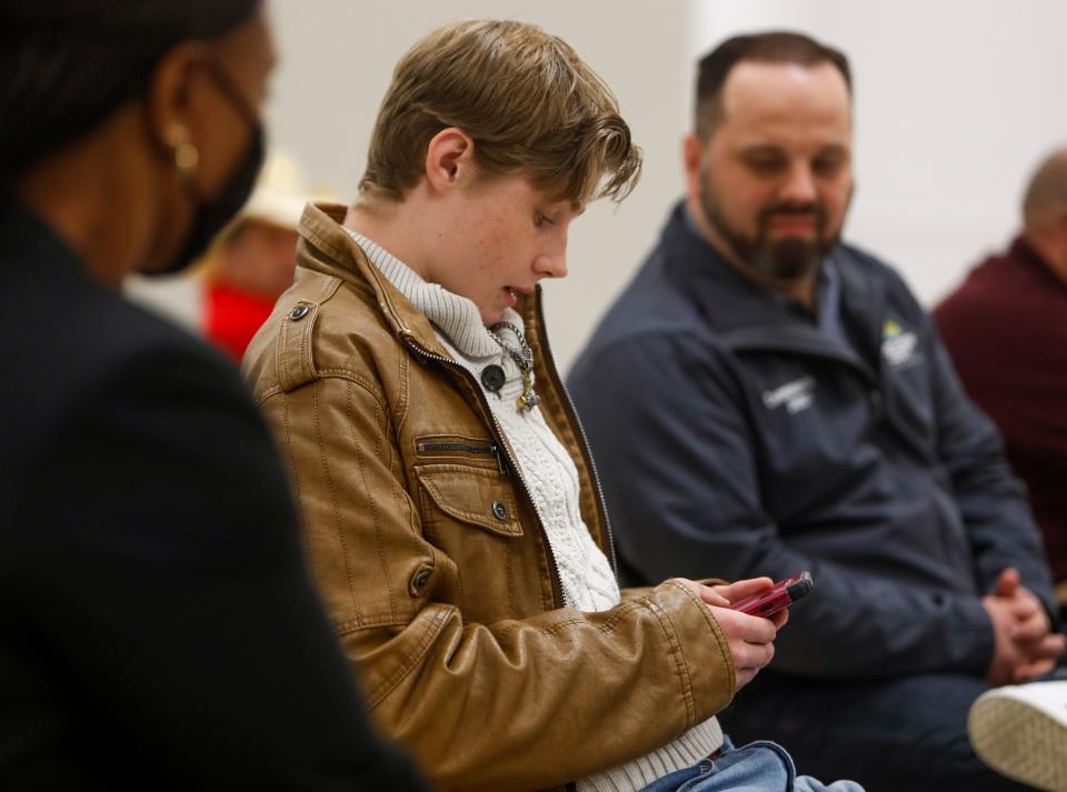 Caleb Bledsoe, a junior in the school system, reads a statement from their phone about feeling like a forgotten class during a meeting asking for public input on the next Director of Schools at the Clarksville-Montgomery County School District headquarters in Clarksville, Tenn., on Tuesday, Jan. 25, 2022. 