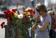 A woman mourns at the place where a protester died amid the clashes with police, in Minsk, Belarus, Tuesday, Aug. 11, 2020. Thousands of opposition supporters who also protested the results met with a tough police crackdown in Minsk and several other Belarusian cities for two straight nights. Belarus' health officials said over 200 people have been hospitalized with injuries following the protests, and some underwent surgery. (AP Photo/Sergei Grits)