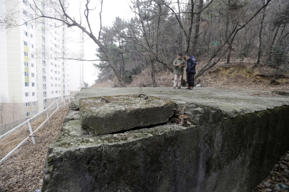 FILE - In this Jan. 28, 2016, file photo, Choi Seung-woo, left, a victim of Brothers Home, and Lee Chae-sik, right, stand on what they say was the location for a water tank at the Brothers Home, in Busan, South Korea. A South Korean facility that kidnapped and abused children, adults, and the disabled for a generation was also shipping children overseas for adoption, part of a massive profit-seeking enterprise that thrived by exploiting those trapped within its walls, The Associated Press has found. Lee, now 50, worked at the Brothers nursery as a boy.(AP Photo/Ahn Young-joon, File)