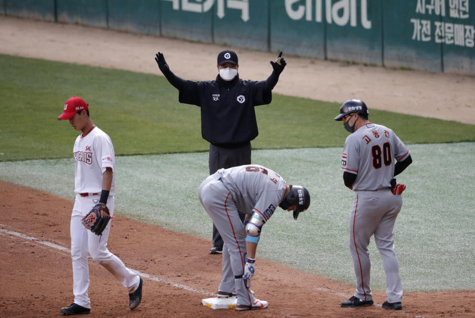 FILE - In this Tuesday, May 5, 2020, file photo, first base umpire Lee Ki-joong, wearing a mask and gloves as a precaution against the new coronavirus, makes a call during a baseball game between Hanwha Eagles and SK Wyverns in Incheon, South Korea. Zimmerman is offering his thoughts as told to AP in a diary of sorts while waiting for the 2020 season to begin. In the sixth installment, he discusses the return to American TV of baseball -- South Korean baseball. (AP Photo/Lee Jin-man, File)