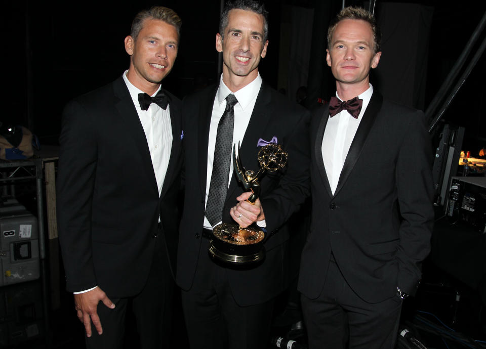 Terry Miller, Dan Savage and Neil Patrick Harris, from left to right, are seen backstage with the Governors Award at the 2012 Creative Arts Emmys at the Nokia Theatre on Saturday, Sept. 15, 2012, in Los Angeles. (Photo by Matt Sayles/Invision/AP)