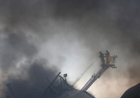 Firefighters extinguish a fire at a garment packaging factory outside Dhaka, Bangladesh, September 10, 2016. REUTERS/Mohammad Ponir Hossain