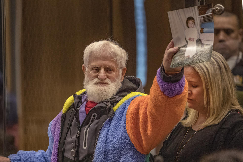 John Milne holds a photograph of his son, Sayyad Milne, who was killed as his daughter, Brydie Henry, right, watches during his victim impact statement during the sentencing hearing for Australian Brenton Harrison Tarrant at the Christchurch High Court after Tarrant pleaded guilty to 51 counts of murder, 40 counts of attempted murder and one count of terrorism in Christchurch, New Zealand, Wednesday, Aug. 26, 2020. More than 60 survivors and family members will confront the New Zealand mosque gunman this week when he appears in court to be sentenced for his crimes in the worst atrocity in the nation's modern history. (John Kirk-Anderson/Pool Photo via AP)