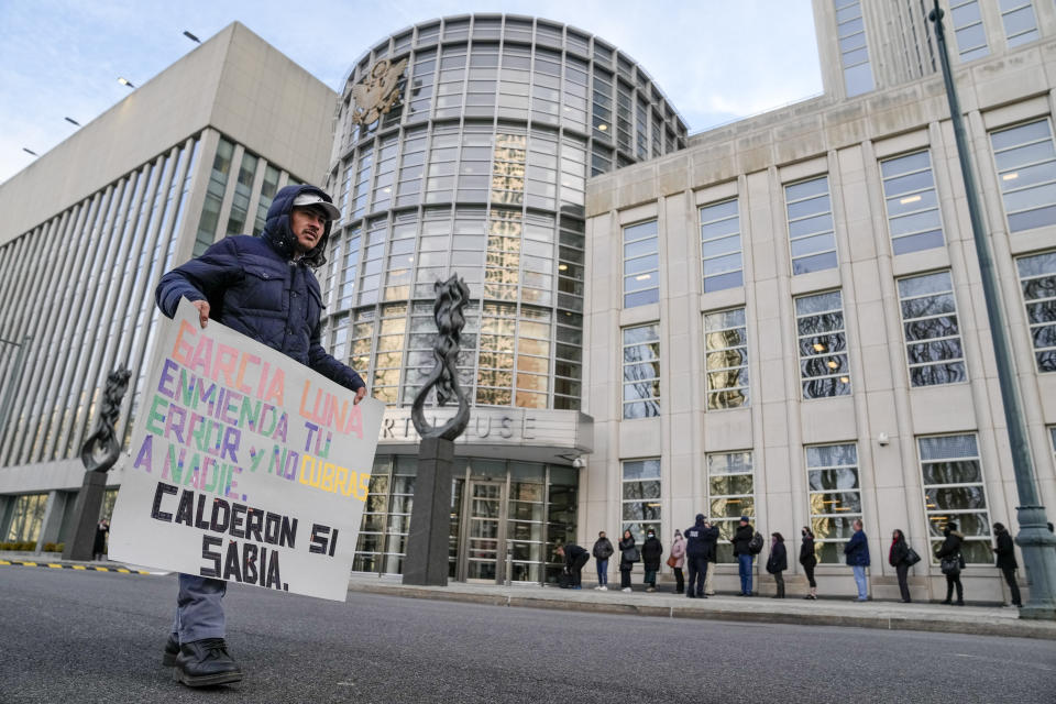 A protestor stands outside Federal court with a sign imploring contrition and cooperation upon Genaro Garcia Luna, Mexico's former top security official, in Brooklyn, Tuesday, Jan. 17, 2023, in New York. Luna goes on trial on charges of helping the Sinaloa Cartel traffic drugs and protect them from capture while he was serving as Mexico’s top security official. (AP Photo/John Minchillo)