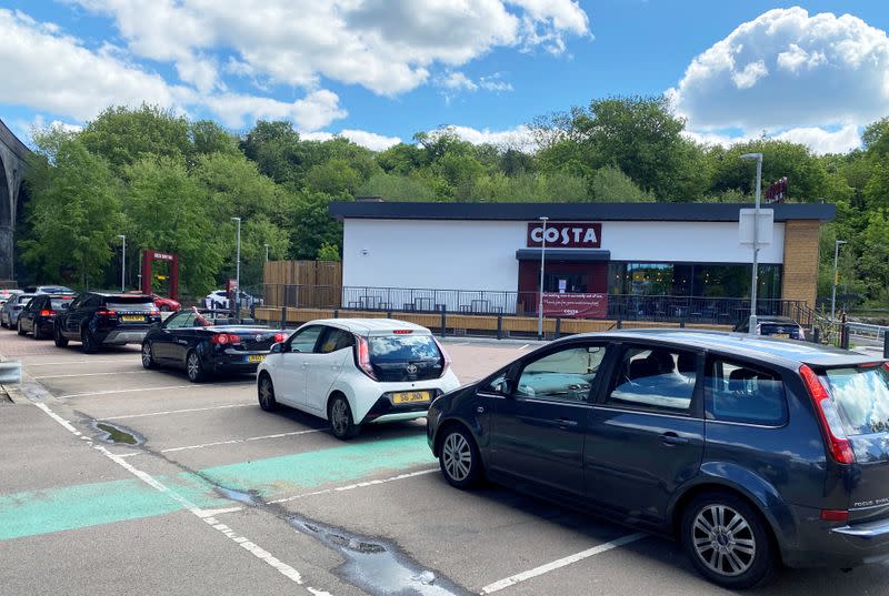 FILE PHOTO: Cars queue at a Costa Coffee drive-thru during the coronavirus outbreak in Watford, Britain