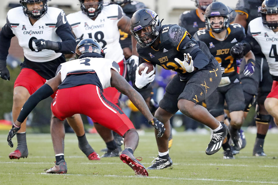 East Carolina's Ryan Jones (13) runs the ball and is challenged by Cincinnati's Ja'von Hicks (3) during the first half of an NCAA college football game in Raleigh, N.C., Friday, Nov. 26, 2021. (AP Photo/Karl B DeBlaker)