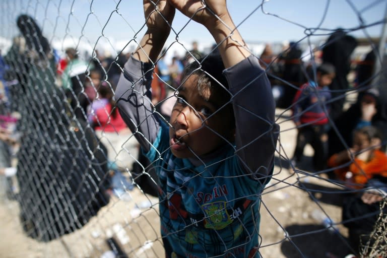 A displaced Iraqi child, who fled the fighting for Mosul between government forces and the Islamic State group jihadists, stands behind a fence at the Hammam al-Alil camp on April 5, 2017