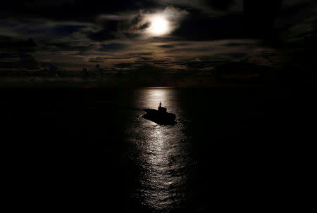 Japanese helicopter carrier Kaga is silhouetted against the reflection of the sun on the ocean during a joint naval drill with British frigate HMS Argyle and Japanese destroyer Inazuma in the Indian Ocean, September 26, 2018. Picture taken September 26, 2018. REUTERS/Kim Kyung-Hoon