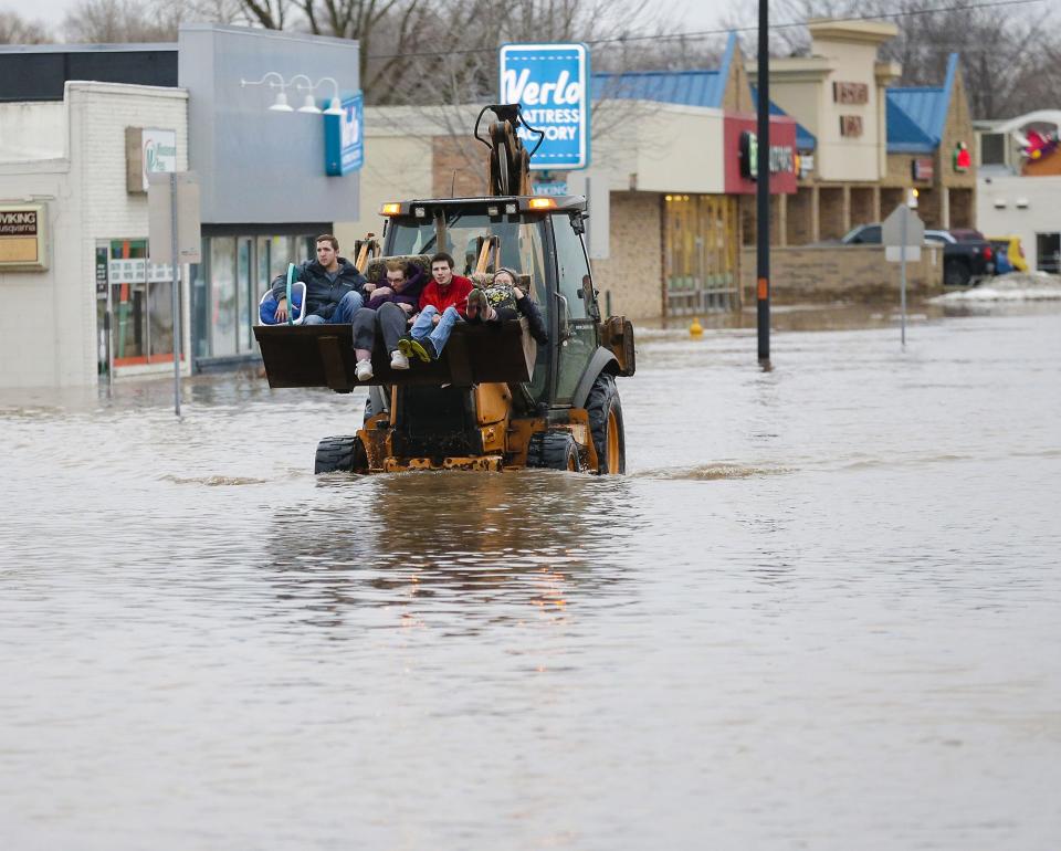 Four people are evacuated from a flooded area Thursday, March 14, 2019 on Johnson Street in Fond du Lac, Wis. Thursday, March 14, 2019. Ice jams on the east branch of the Fond du Lac River and heavy rain caused widespread flooding problems in the city. Doug Raflik/USA TODAY NETWORK-Wisconsin