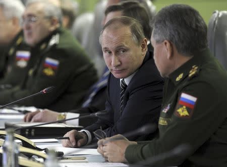 Russian President Vladimir Putin looks at Defence Minister Sergei Shoigu as they attend a meeting dealing with the commissioning of military products at the National defence control centre in Moscow, Russia, in this March 11, 2016 file photo. REUTERS/Mikhail Klimentyev/Sputnik/Kremlin/Files