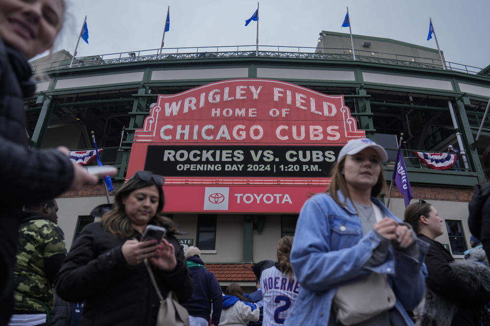 People gather outside Wrigley Field before an opening day baseball game between the Colorado Rockies and Chicago Cubs Monday, April 1, 2024, in Chicago. (AP Photo/Erin Hooley)