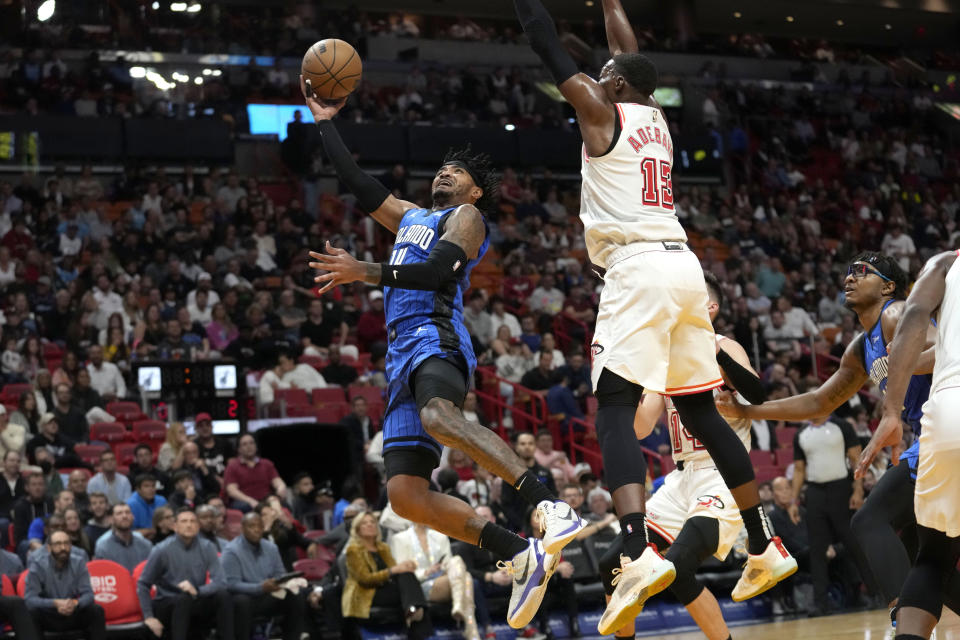 Orlando Magic guard Gary Harris, left goes to the basket as Miami Heat center Bam Adebayo (13) defends during the first half of an NBA basketball game, Friday, Jan. 27, 2023, in Miami. (AP Photo/Lynne Sladky)