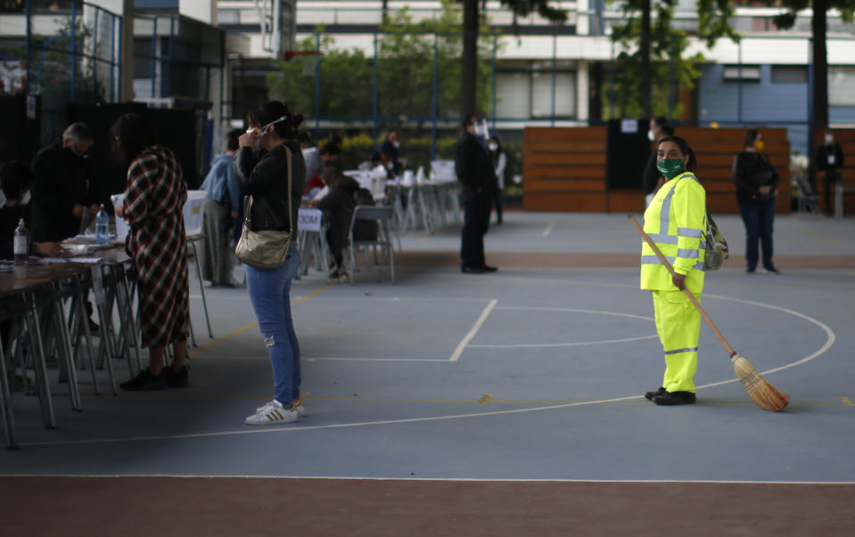 People line up for their turn to vote at a polling station during a referendum to decide whether the country should replace its 40-year-old constitution, in Santiago, Chile, Sunday, Oct. 25, 2020. (AP Photo/Luis Hidalgo)