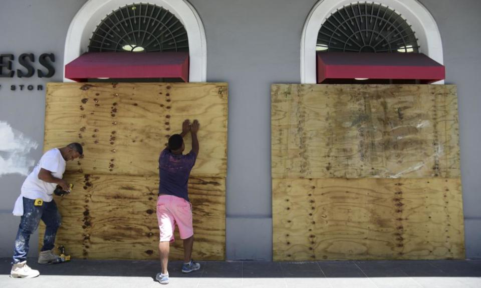 Workers cover shop windows with wood in preparation for protests against Governor Ricardo Rosselló near La Fortaleza in San Juan, Puerto Rico, on Wednesday.