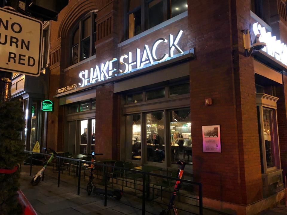 A Shake Shack restaurant at night in downtown Washington DC, featuring a lighted "Shake Shack" sign