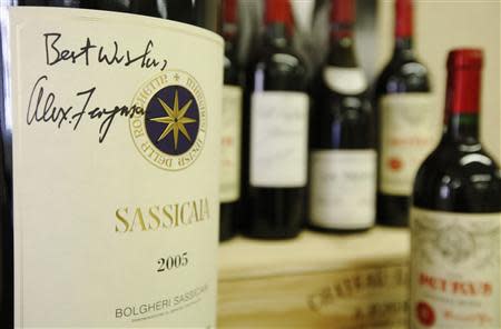 A six litre imperiale "Sassicaia 2005" wine, signed by retired Manchester United boss Alex Ferguson, is seen with other wines owned by Ferguson, at Christie's auction house in London April 14, 2014. REUTERS/Luke MacGregor