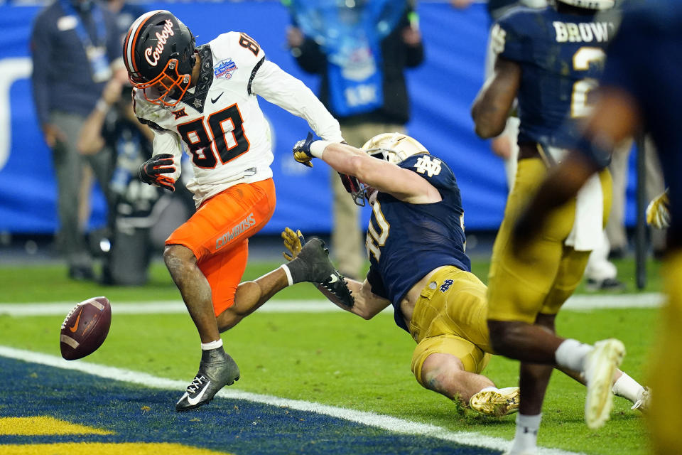 Oklahoma State wide receiver Brennan Presley (80) fumbles the football at the goal line as Notre Dame linebacker Drew White (40) defends during the second half of the Fiesta Bowl NCAA college football game, Saturday, Jan. 1, 2022, in Glendale, Ariz. (AP Photo/Ross D. Franklin)