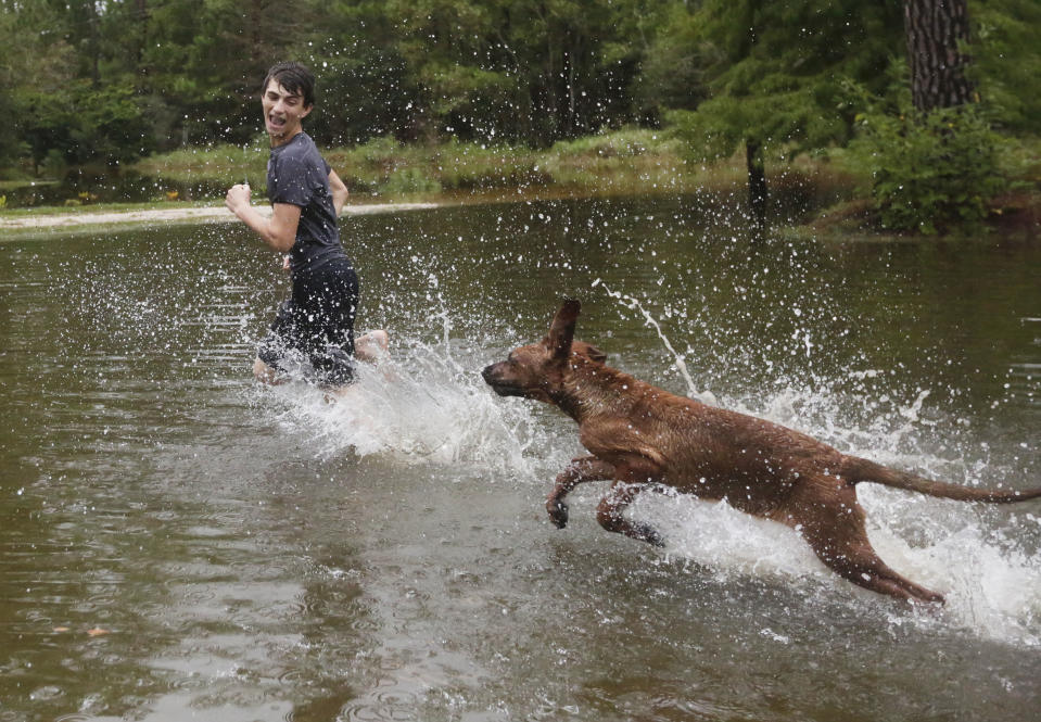 <p>Tim Neilsen III, 16, is chased by his dog “Chevy” through flood waters that filled their front yard after Hurricane Nate, Sunday, Oct. 8, 2017, in Coden, Ala. (Photo: Brynn Anderson/AP) </p>