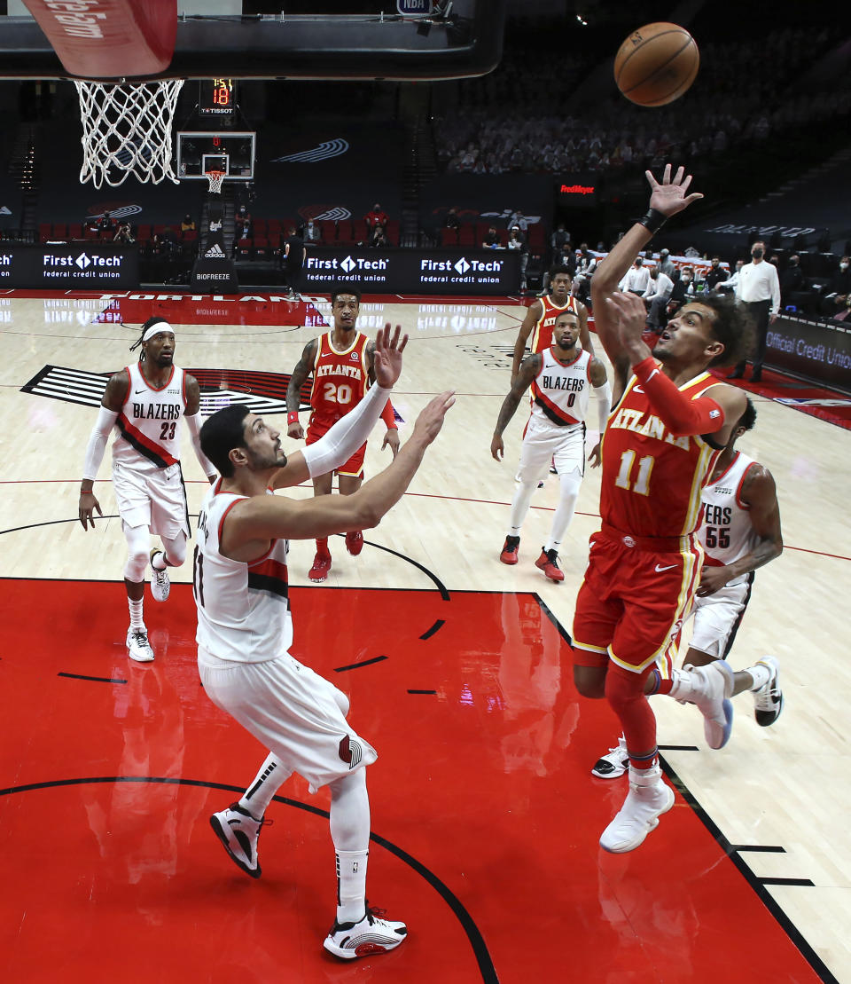 Atlanta Hawks guard Trae Young, right, shoots over Portland Trail Blazers center Enes Kanter during the first half of an NBA basketball game in Portland, Ore., Saturday, Jan. 16, 2021. (AP Photo/Craig Mitchelldyer)