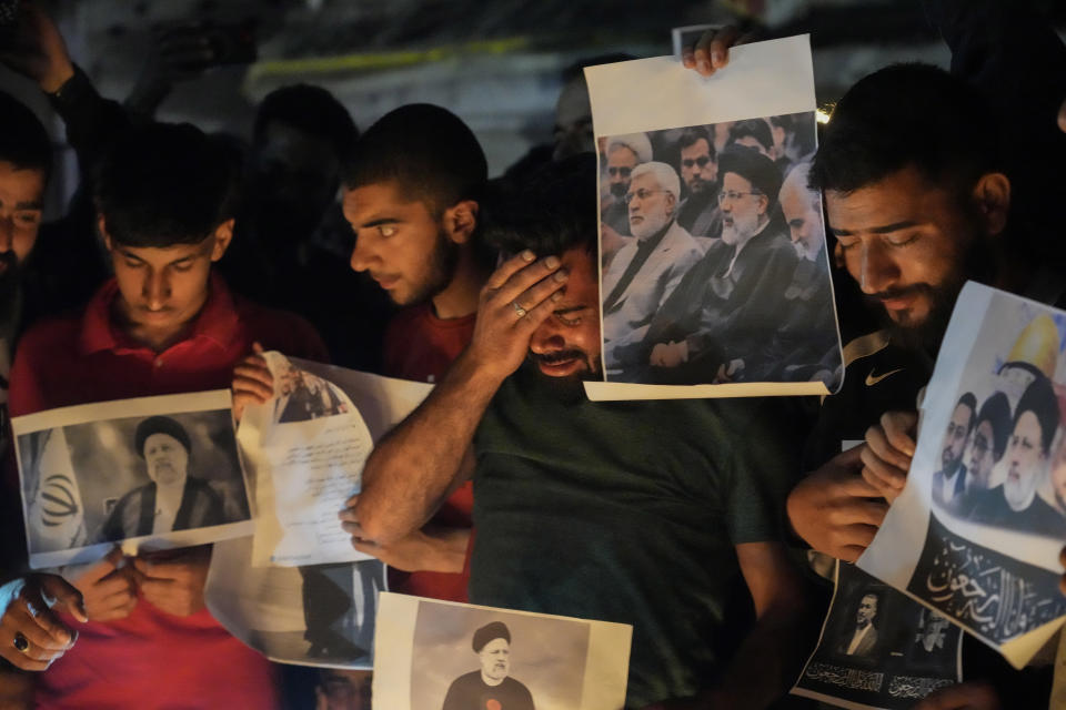 A Shiite Muslim weeps as they hold photos of Iranian President Ebrahim Raisi and others leaders during a vigil in Srinagar, Indian controlled Kashmir, Monday, May 20, 2024. Raisi and several other officials were found dead on Monday, hours after their helicopter crashed in a foggy, mountainous region of Iran's northwest, state media reported. (AP Photo/Mukhtar Khan)