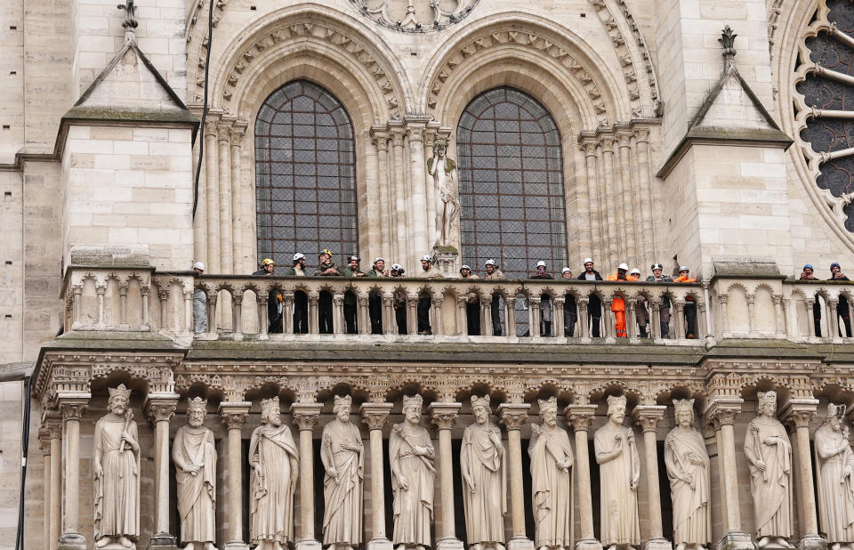 Craftsmen workers stand on the balcony of the cathedral as Britain's King Charles III and Queen Camilla pay a visit tp the Notre-Dame de Paris Cathedral rebuilding site in Paris, Thursday, Sept, 21 2023. On the second day of his state visit to France, King Charles met with sports groups in the northern suburbs of Paris and pays a visit to fire-damaged Notre-Dame cathedral. (Christophe Petit Tesson, Pool via AP)