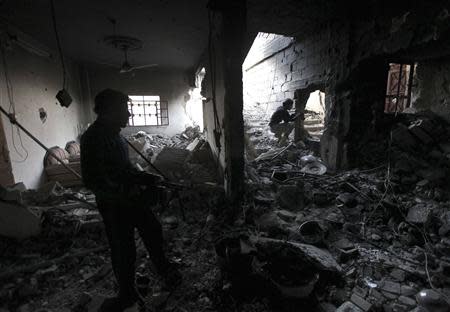 Free Syrian Army fighters take up position inside a damaged house filled with debris in Deir al-Zor, eastern Syria November 14, 2013. REUTERS/Khalil Ashawi