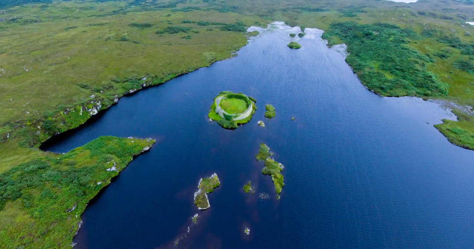 <p>The astonishingly green fields of Donegal encircle a bright blue lake.</p>