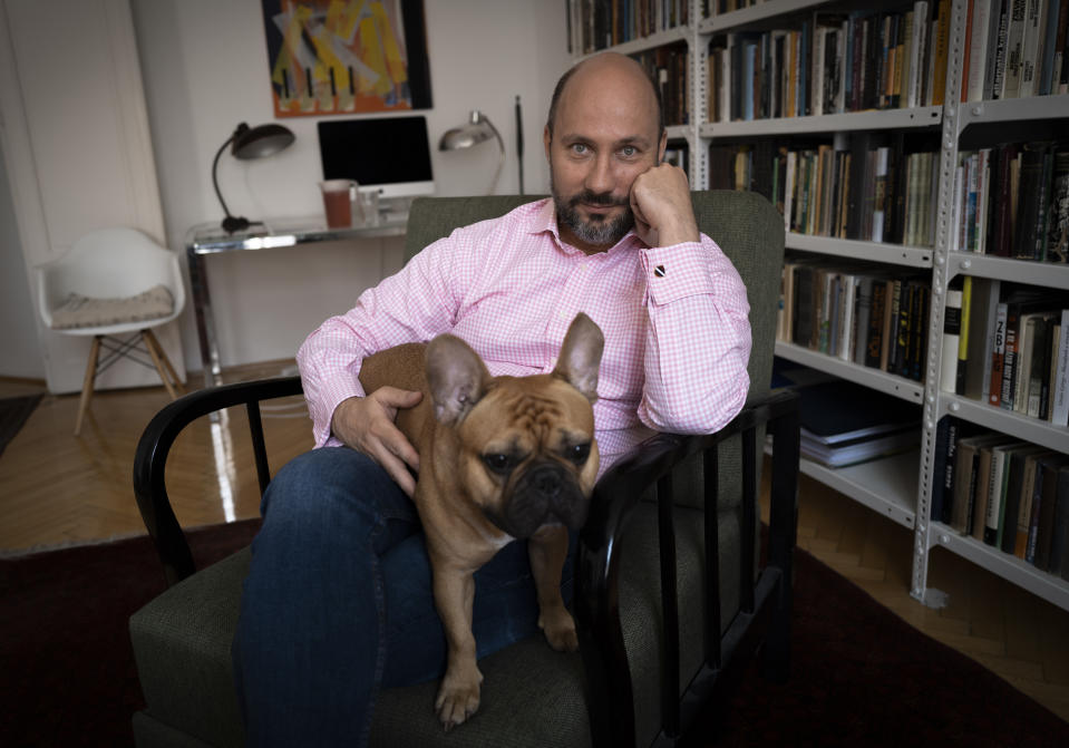 Novelist Mark Mezei poses for a photo in his home in Budapest, Tuesday, July 13, 2021. A recent Hungarian law that prohibits “depicting or promoting” homosexuality or sex reassignment to minors has some bookstores in Hungary placing notices at their entrances, warning customers over books containing “non-traditional content.” Some writers and publishers say the controversial law narrows free thought and expression in literature - and are uncertain over whether works that depict homosexual themes will require labeling to keep them from reaching minors under 18. (AP Photo/Bela Szandelszky)