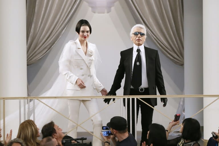 German fashion designer Karl Lagerfeld acknowledges the public along with US model Kendall Jenner during the Chanel fashion show at the Grand Palais in Paris, on July 7, 2015