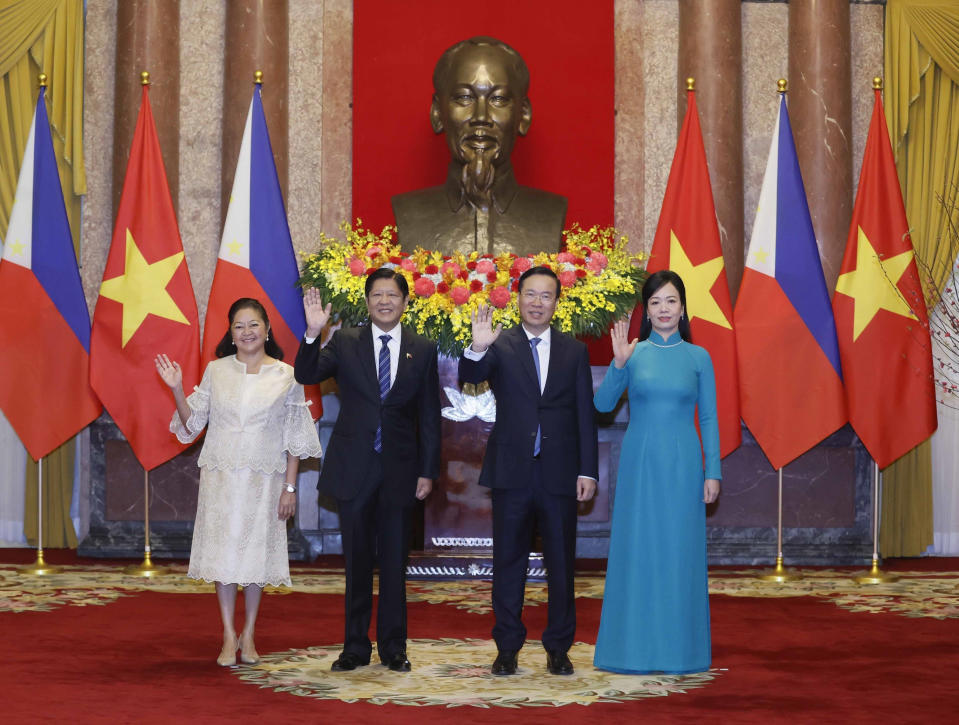 Philippine President Ferdinand Marcos Jr., second left, and Vietnamese President Vo Van Thuong and their wives wave to the media before a meeting in Hanoi, Vietnam, Tuesday, Jan. 30, 2024. Marcos Jr. is on a two-day visit to Hanoi. (Hoang Thong Nhat/VNA via AP)