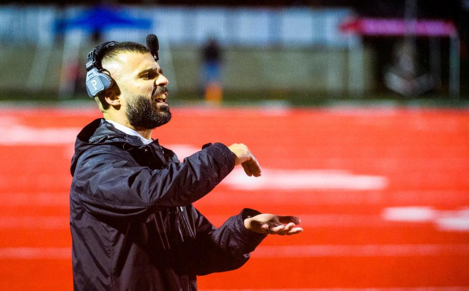 Edgewood head coach Caleb True signals a play into his team during the Edgewood versus Vincennes Lincoln sectional football game at Edgewood High School Friday, Oct. 29, 2021.