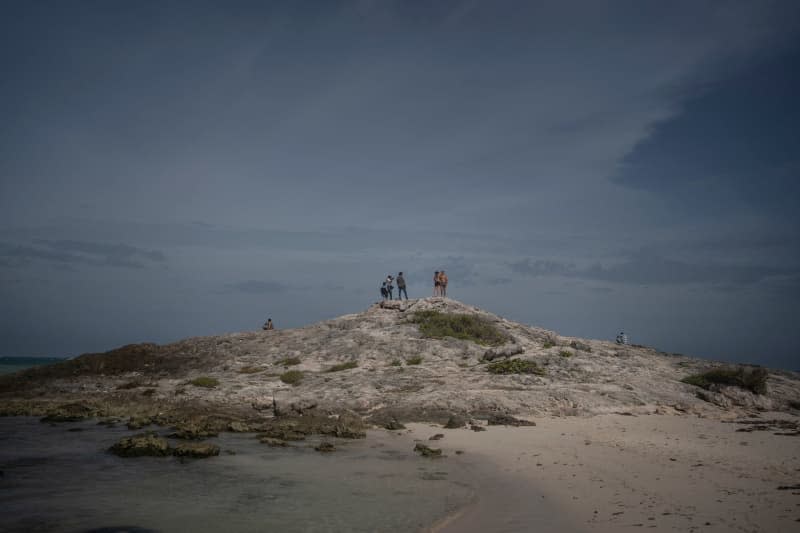 A group of people look out to sea before the arrival of Hurricane Beryl. Felix Marquez/dpa