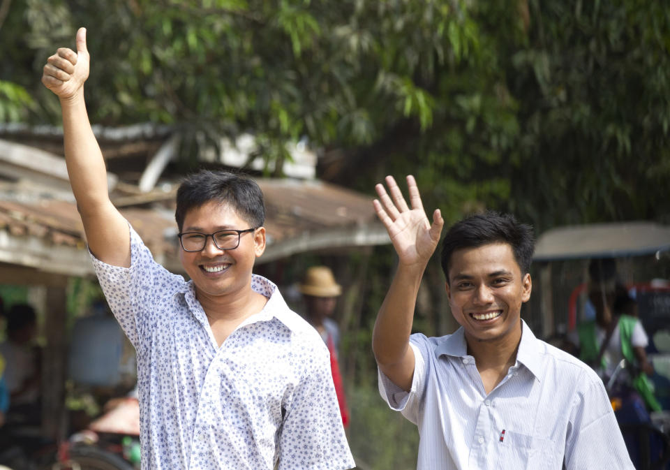 Reuters journalists Wa Lone, left, and Kyaw She Oo wave as they walk out from Insein Prison after being released in Yangon, Myanmar Tuesday, May 7, 2019. Two Reuters journalists who were imprisoned for breaking Myanmar's Official Secrets Act over reporting on security forces' abuses of Rohingya Muslims were pardoned and released Tuesday, the prison chief and witnesses said. (AP Photo/Thein Zaw)