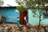 Sandra Saccaco, a resident of Nueva Union shantytown who plays volleyball at a makeshift soccer field, and her daughter Cristel Acevedo leave home to go to school in Villa Maria del Triunfo district of Lima, Peru, June 1, 2018. REUTERS/Mariana Bazo