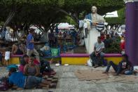 A group of migrants rests at the central park in Ciudad Hidalgo, Mexico, Saturday, Oct. 20, 2018. About 2,000 Central American migrants who circumvented Mexican police at a border bridge and swam, forded and floated across the river from Guatemala decided on Saturday to re-form their mass caravan and continue their trek northward toward the United States. (AP Photo/Oliver de Ros)