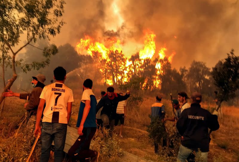 FILE PHOTO: Villagers attempt to put out a wildfire, in Achallam village