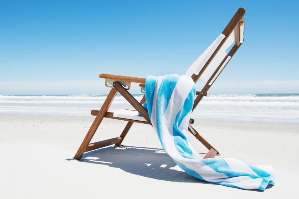 beach towel hanging over beach chair